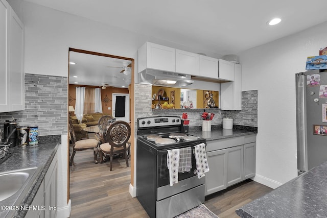 kitchen featuring appliances with stainless steel finishes, extractor fan, white cabinetry, and tasteful backsplash