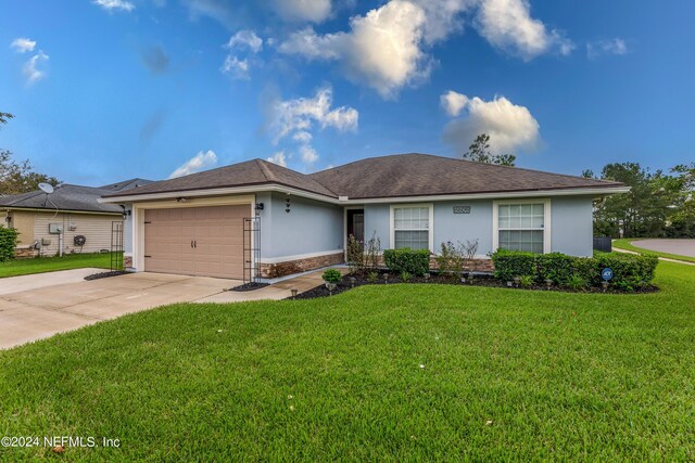 single story home featuring a front lawn and a garage