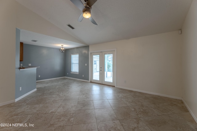 tiled empty room with a textured ceiling, french doors, ceiling fan, and vaulted ceiling