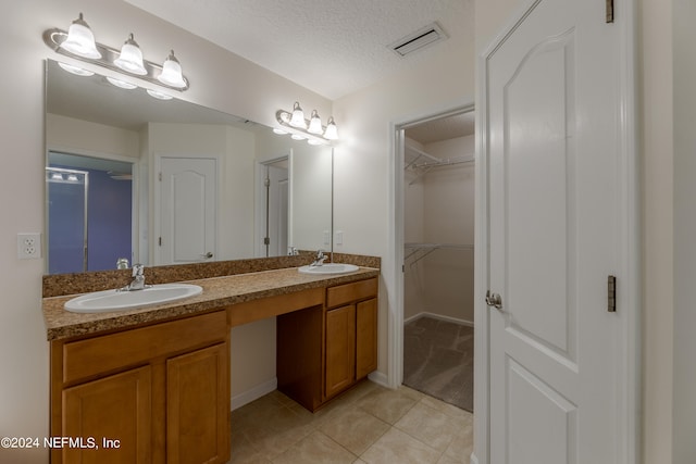 bathroom with vanity, a textured ceiling, and tile patterned floors