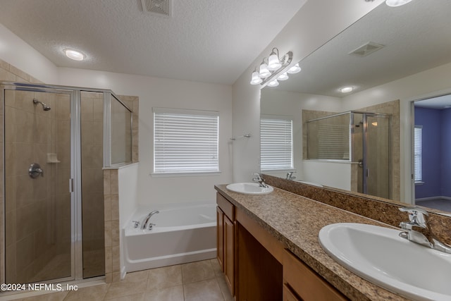 bathroom with independent shower and bath, vanity, a textured ceiling, and tile patterned floors