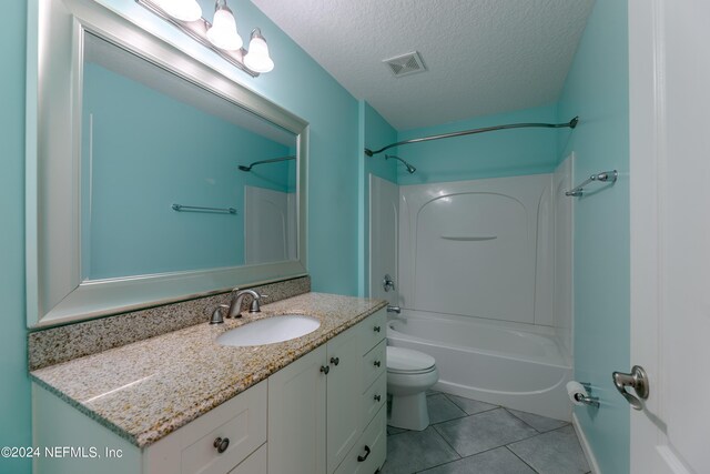 full bathroom with tile patterned flooring, bathtub / shower combination, toilet, vanity, and a textured ceiling