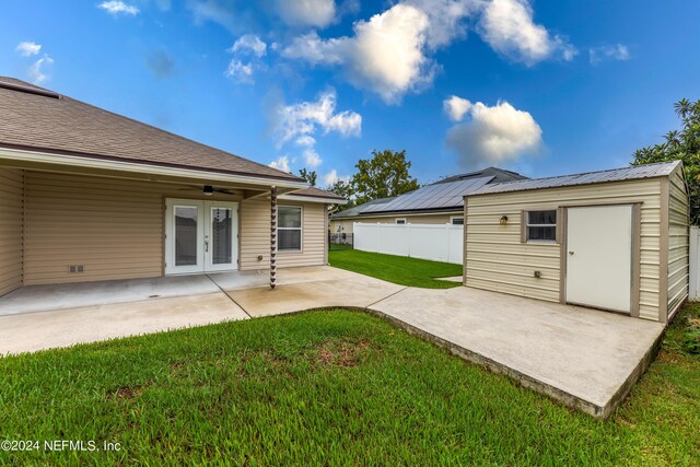 view of yard featuring a storage unit, ceiling fan, a patio area, and french doors