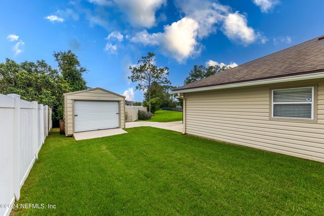 view of yard with a garage and an outbuilding