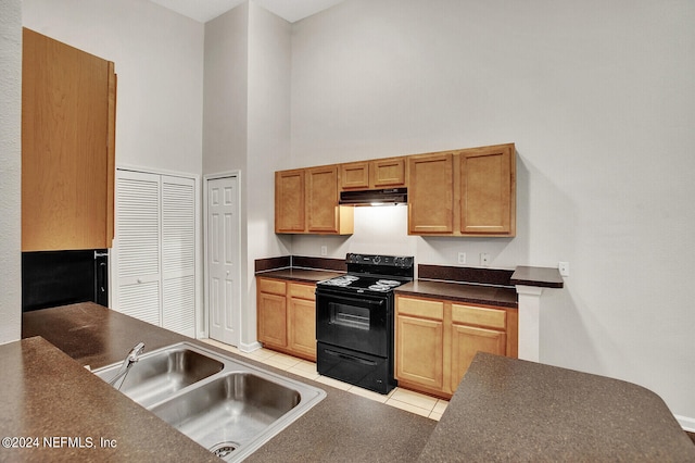 kitchen featuring a towering ceiling, light tile patterned floors, black range with electric stovetop, and sink