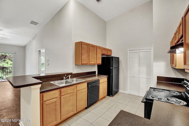 kitchen with black appliances, kitchen peninsula, sink, and high vaulted ceiling