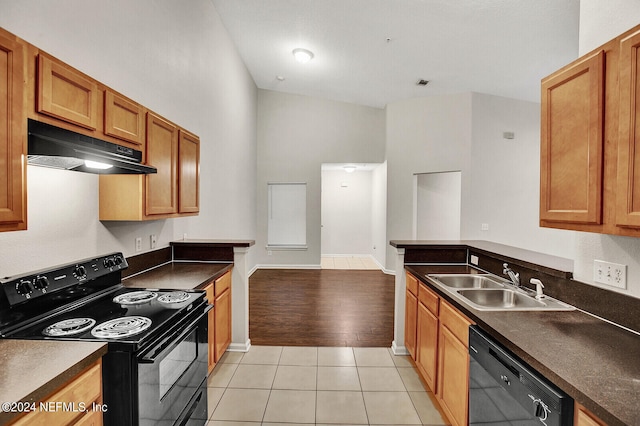 kitchen with lofted ceiling, black appliances, sink, and light wood-type flooring