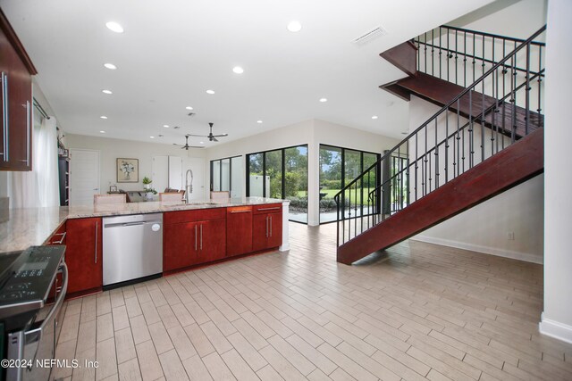 kitchen featuring ceiling fan, sink, light hardwood / wood-style flooring, appliances with stainless steel finishes, and light stone countertops