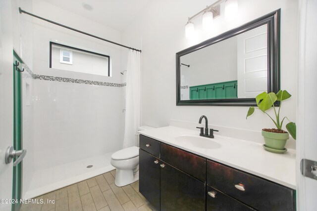 bathroom with curtained shower, vanity, and toilet