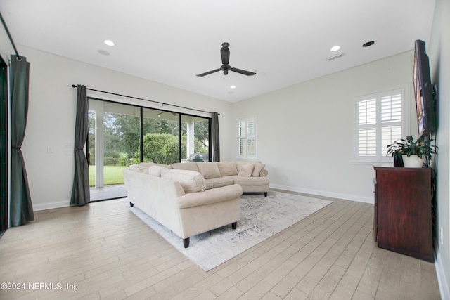 living room with light hardwood / wood-style flooring and ceiling fan