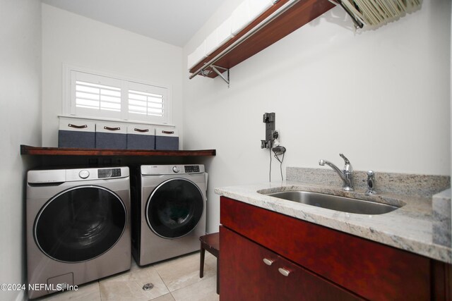 laundry area featuring light tile patterned flooring, sink, and independent washer and dryer