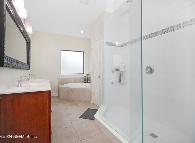 bathroom featuring plus walk in shower, tile patterned flooring, and vanity