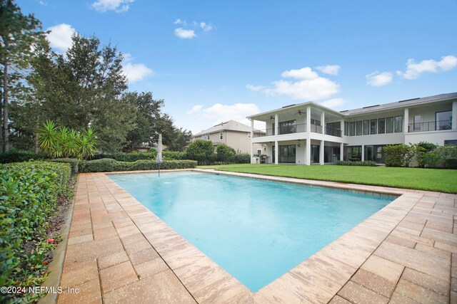 view of swimming pool with a yard