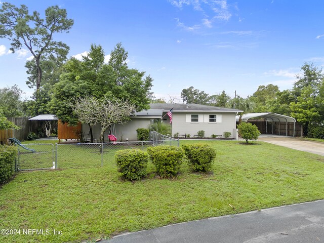 ranch-style home with a front yard and a carport