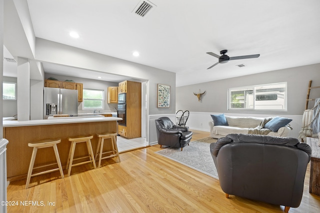 living room featuring light hardwood / wood-style flooring and ceiling fan