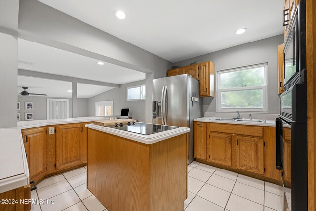 kitchen featuring ceiling fan, light tile patterned flooring, sink, a kitchen island, and black appliances