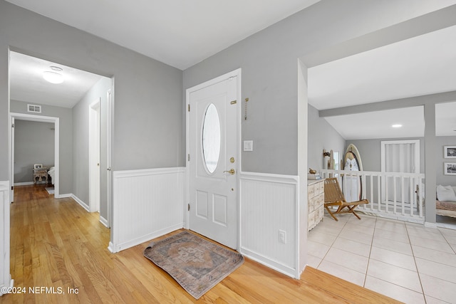 foyer featuring light wood-type flooring and lofted ceiling