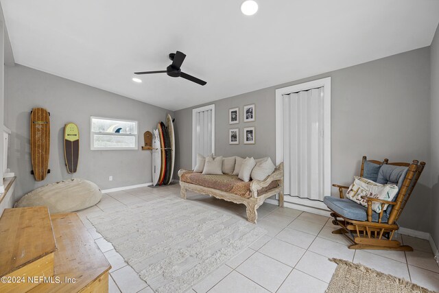 living room with light tile patterned floors, lofted ceiling, and ceiling fan