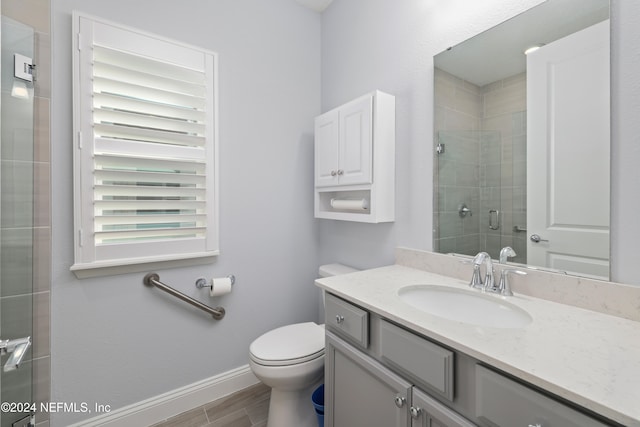 bathroom featuring toilet, an enclosed shower, hardwood / wood-style floors, and vanity