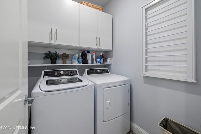 washroom featuring cabinets and washer and clothes dryer