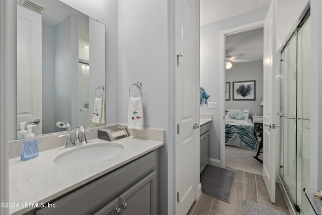 bathroom featuring a shower with door, vanity, and ceiling fan