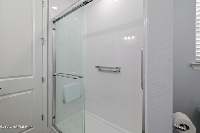 bathroom with a shower with door