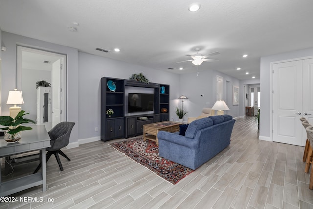 living room featuring ceiling fan and light hardwood / wood-style flooring