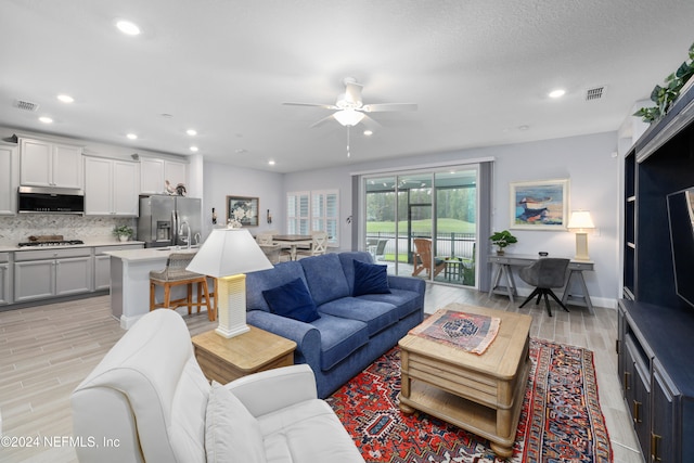 living room featuring light hardwood / wood-style floors and ceiling fan