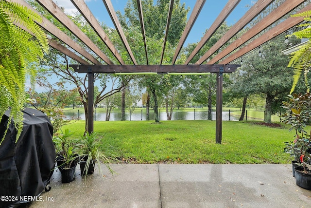 view of yard with a pergola, a water view, and a patio area