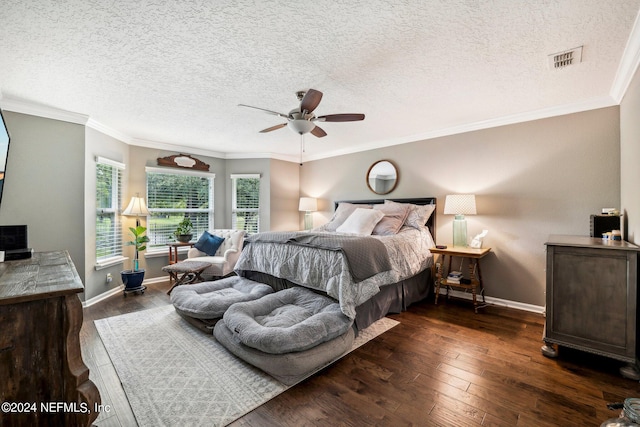 bedroom with a textured ceiling, crown molding, ceiling fan, and dark wood-type flooring