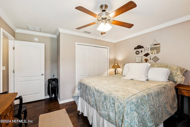 bedroom with a closet, a textured ceiling, dark wood-type flooring, ornamental molding, and ceiling fan