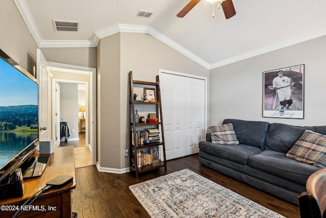 living room featuring a textured ceiling, dark wood-type flooring, lofted ceiling, ornamental molding, and ceiling fan