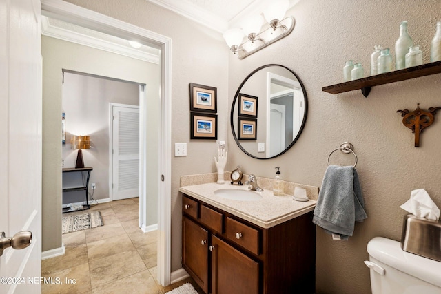 bathroom featuring vanity, crown molding, toilet, and tile patterned floors