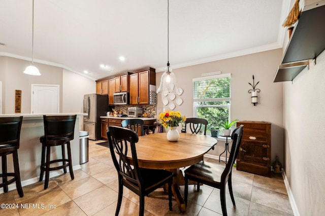 tiled dining space featuring crown molding