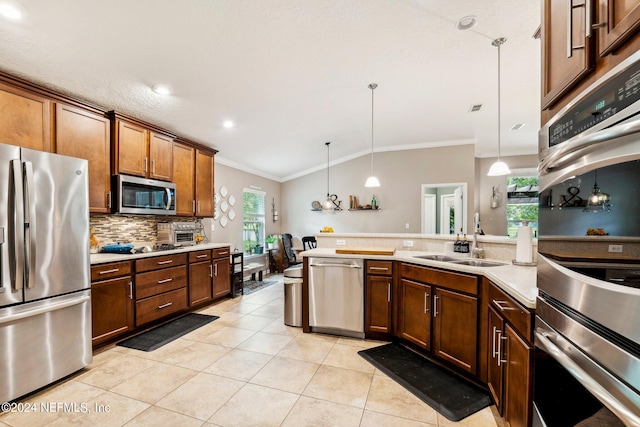 kitchen with pendant lighting, stainless steel appliances, plenty of natural light, and sink