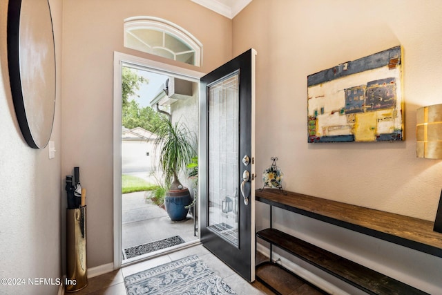 tiled foyer entrance featuring crown molding