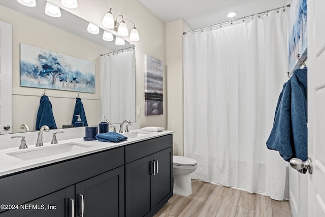 bathroom with wood-type flooring, toilet, and vanity