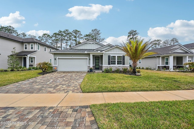 view of front facade featuring a garage, stone siding, decorative driveway, board and batten siding, and a front yard