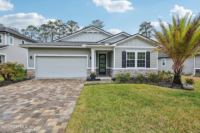 craftsman-style house featuring stone siding, decorative driveway, board and batten siding, and a front yard