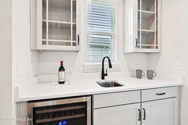 bar featuring beverage cooler and a sink