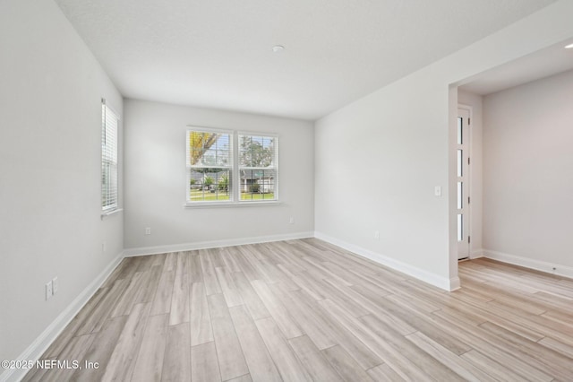 empty room featuring light wood-style floors and baseboards