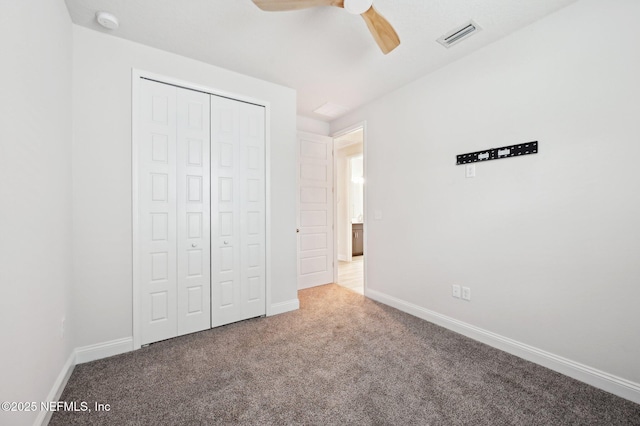 unfurnished bedroom featuring ceiling fan, carpet flooring, visible vents, baseboards, and a closet