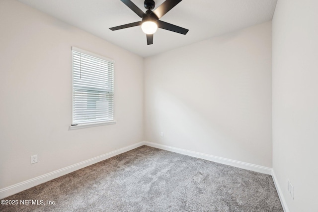 carpeted spare room with a ceiling fan and baseboards