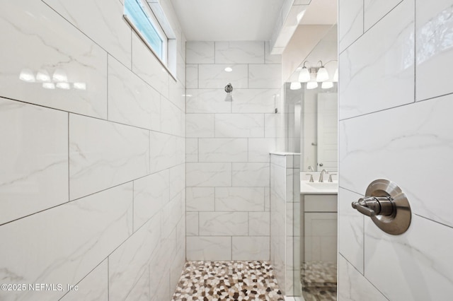 full bath with tiled shower and vanity