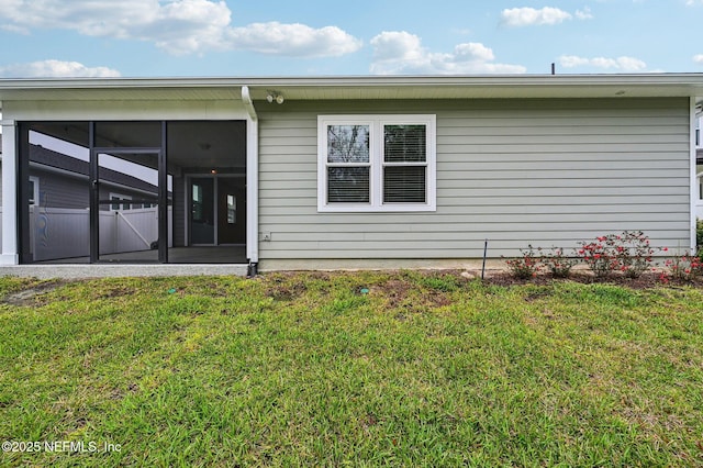 rear view of property with a sunroom and a lawn