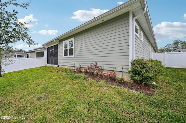 rear view of house with fence and a lawn