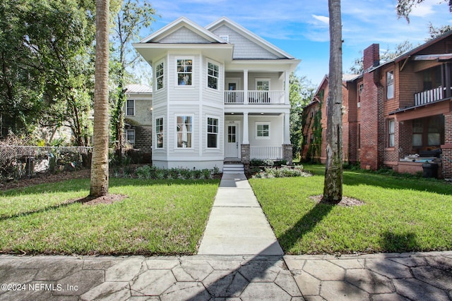 view of front of house with a balcony and a front lawn