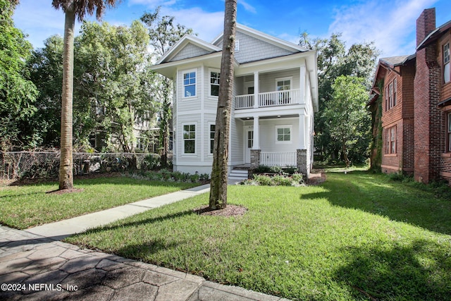 greek revival house featuring a front yard, a balcony, and a porch