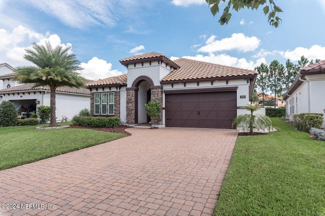 mediterranean / spanish house with a front yard and a garage