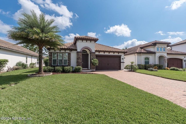 mediterranean / spanish-style home with a front lawn and a garage